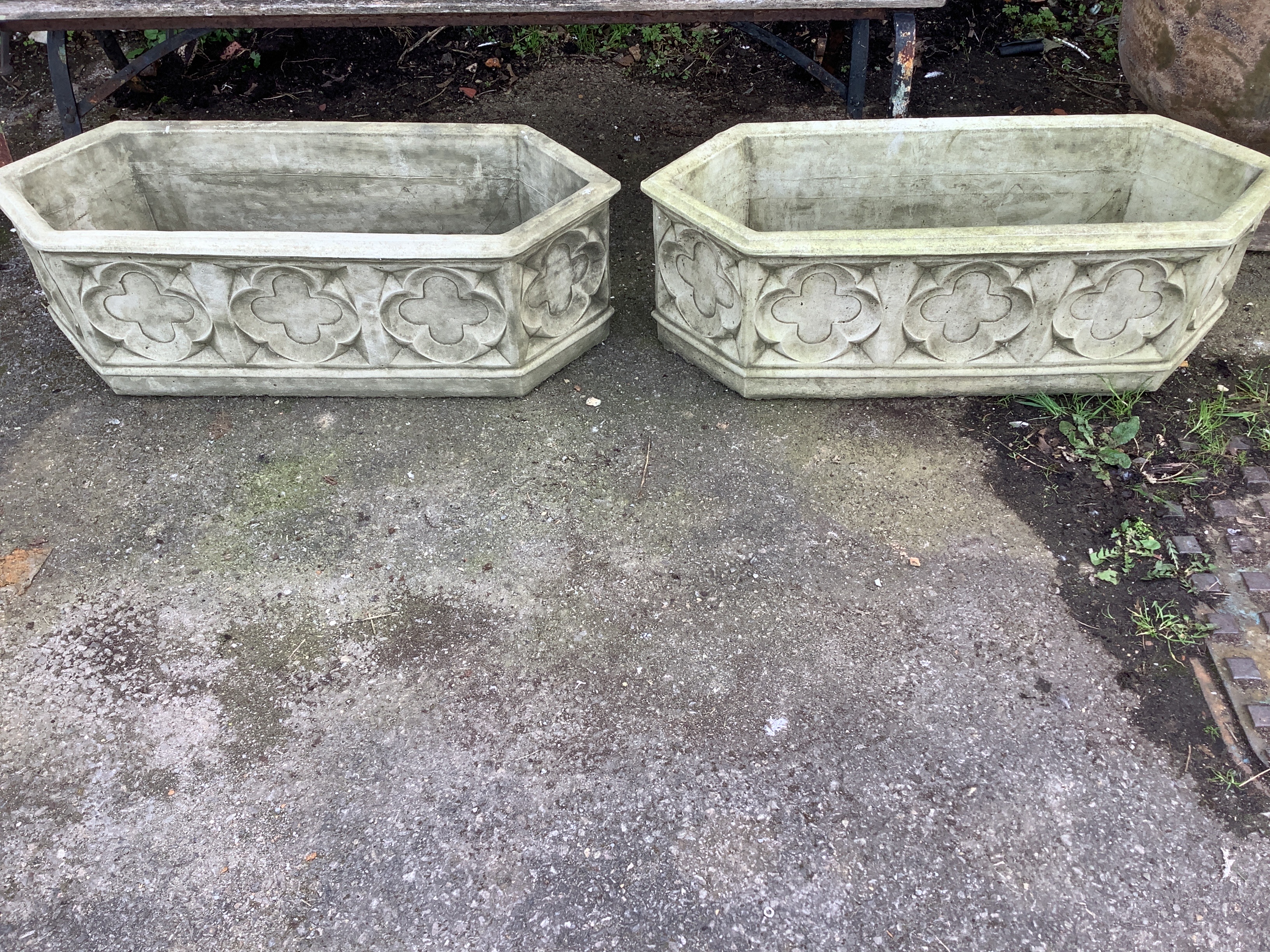 A pair of cast stone Gothic style garden planters of elongated hexagonal form, width 88cm, depth 33cm, height 29cm